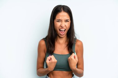 İspanyol asıllı güzel bir kadın sinirli, sinirli bakışlar ve sıkı yumruklar ile agresif bir şekilde bağırıyor.