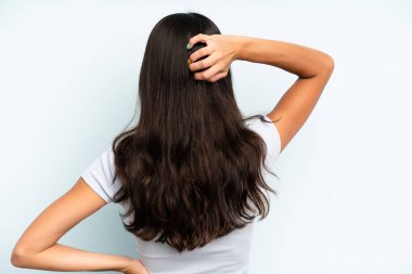 Hispanik güzel kadın düşünüyor ya da şüphe ediyor, kafasını kaşıyor, şaşkın ve şaşkın hissediyor, arkaya ya da arkaya bakıyor.