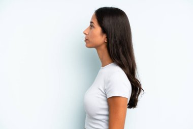 Latin kökenli güzel kadın profil görünümünde uzayı kopyalamaya çalışıyor, düşünüyor, hayal ediyor ya da hayal kuruyor.