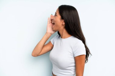 İspanyol güzel kadın profil görüşü, mutlu ve heyecanlı görünüyor, bağırıyor ve kenardaki boşluğu kopyalamak için arıyor