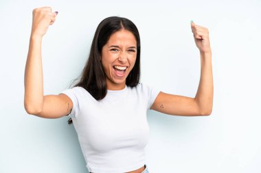 İspanyol güzel kadın muzaffer bir şekilde bağırıyor. Heyecanlı, mutlu ve şaşırmış görünüyor. Kutlama yapıyor.