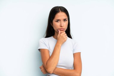 İspanyol güzel kadın ciddi görünüyor, kafası karışık, kararsız ve düşünceli, seçenekler veya seçimler arasında şüpheci.