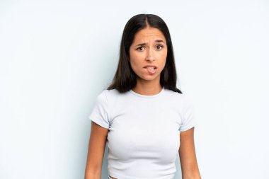 İspanyol güzel kadın şaşkın ve şaşkın görünüyor. Sinirli bir hareketle dudağını ısırıyor. Sorunun cevabını bilmiyor.