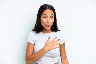 İspanyol güzel kadın şaşkın ve şaşırmış hissediyor, gülümsüyor, el ele tutuşuyor, mutlu ya da minnettarlık gösteriyor.