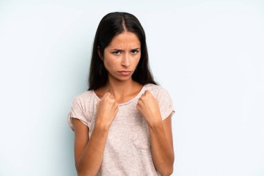 İspanyol güzel kadın kendinden emin, sinirli, güçlü ve agresif görünüyor. Yumrukları boks pozisyonunda dövüşmeye hazır.