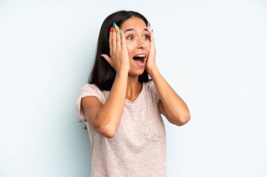 İspanyol güzel kadın mutlu, heyecanlı ve şaşırmış hissediyor, iki eli yüzü yana bakıyor