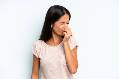 İspanyol güzel kadın iğreniyor, kötü ve nahoş bir koku duymamak için burnunu tutuyor.