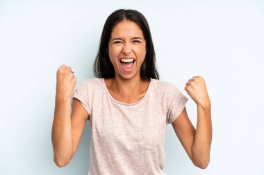 İspanyol asıllı güzel bir kadın öfkeli bir ifadeyle saldırganca bağırıyor ya da yumruklarıyla başarıyı kutluyor.