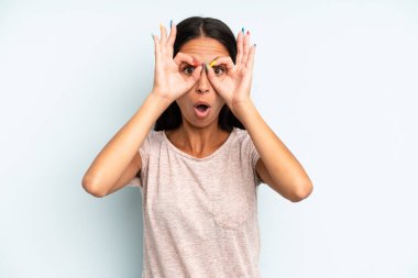 İspanyol güzel kadın şaşkın, şaşkın ve şaşırmış hissediyor, elinde şaşkın, inançsız bir bakışla gözlük tutuyor.