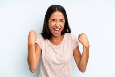 İspanyol güzel kadın mutlu, pozitif ve başarılı hissediyor, zaferi, başarıları veya iyi şansı kutluyor.