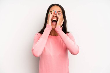 İspanyol güzel kadın mutlu, heyecanlı ve pozitif hissediyor. Elleri ağızda, bağırarak bağırıyor.