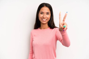 İspanyol güzel kadın gülümsüyor ve arkadaş canlısı görünüyor. İki ya da iki numarayı gösteriyor. Elleri önde, geriye doğru sayıyor.