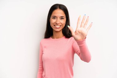 İspanyol güzel kadın gülümsüyor ve arkadaş canlısı görünüyor, 5 ya da 5 numarayı gösteriyor, elleri önde, geriye doğru sayıyor.