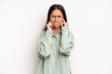 İspanyol güzel kadın sinirli, stresli ve sinirli görünüyor, iki kulağını da sağır edici bir ses, ses ya da yüksek sesle kapatıyor.