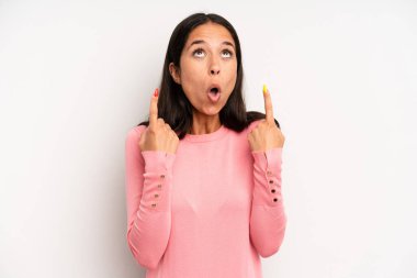 İspanyol güzel kadın şaşırmış, şaşırmış ve ağzı açık görünüyor, iki eliyle boşluğu kopyalamak için yukarı bakıyor.