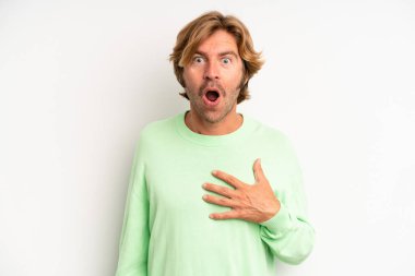 Sarışın, yetişkin bir adam şaşkın ve şaşırmış hissediyor, gülümsüyor, el ele tutuşuyor, o olmaktan mutlu ya da minnettarlık gösteriyor.