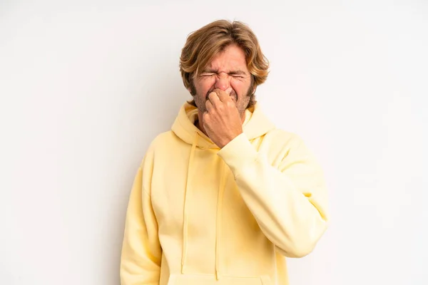 金髪の大人の男は気分が悪く不快な臭いを避けるために鼻を保持し うんざり — ストック写真