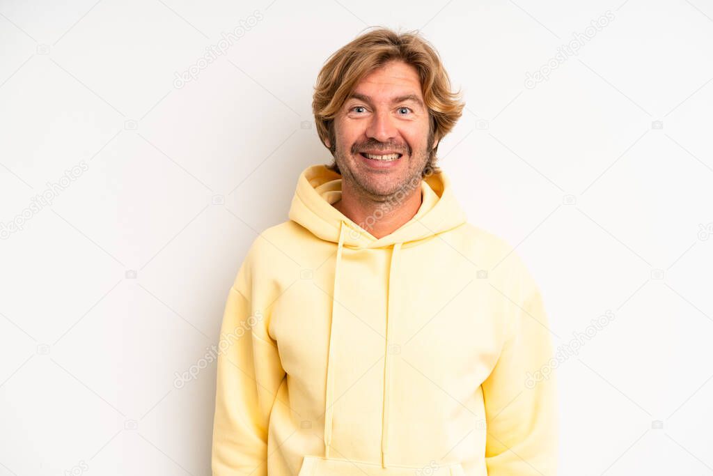blond adult man looking happy and pleasantly surprised, excited with a fascinated and shocked expression