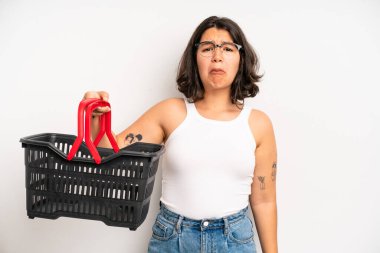 İspanyol güzel kız üzgün ve mızmızlanıyor. Mutsuz bir bakışı var ve ağlıyor. boş alışveriş sepeti kavramı