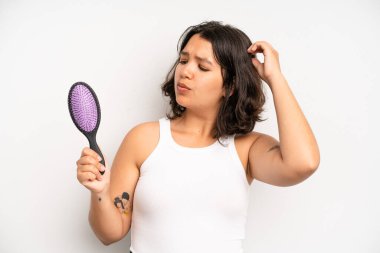 hispanic pretty girl feeling cross,showing thumbs down. hair comb concept