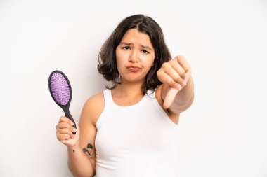 hispanic pretty girl feeling happy and pointing to self with an excited. hair comb concept