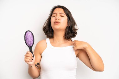 hispanic pretty girl smiling and looking friendly, showing number four. hair comb concept