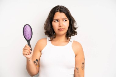 hispanic pretty girl looking angry, annoyed and frustrated. hair comb concept