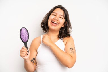 hispanic pretty girl thinking, feeling doubtful and confused. hair comb concept