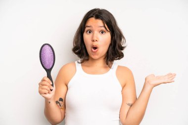 hispanic pretty girl feeling puzzled and confused. hair comb concept