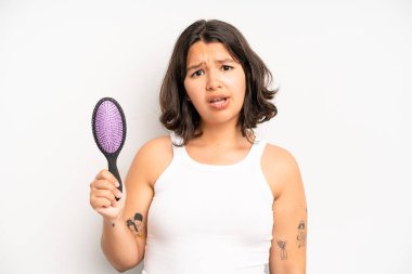 hispanic pretty girl feeling extremely shocked and surprised. hair comb concept