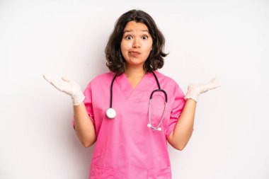 hispanic pretty girl smiling and looking happy, gesturing victory or peace. nurse concept