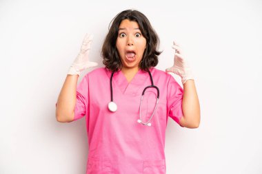 hispanic pretty girl covering mouth with hands with a shocked. nurse concept