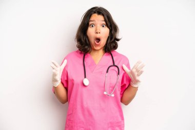hispanic pretty girl smiling happily and daydreaming or doubting. nurse concept