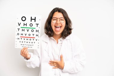 hispanic pretty girl feeling shocked,laughing and celebrating success. optical vision test concept