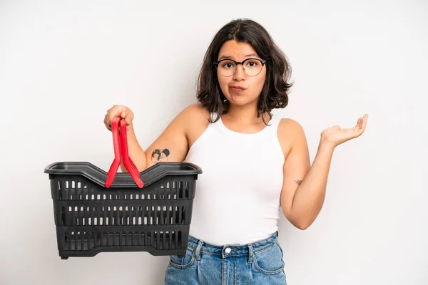 Hispanic Pretty Girl Feeling Puzzled Confused Doubting Empty Shopping Basket — Stock Photo, Image