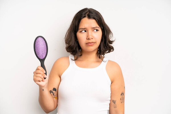 Латиноамериканка выглядит злой, раздраженной и расстроенной. Концепция расчески волос