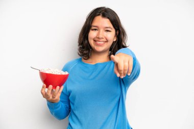 hispanic pretty girl smiling with a happy, confident expression with hand on chin. breakfast concept