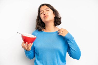 hispanic pretty girl shrugging, feeling confused and uncertain. breakfast concept