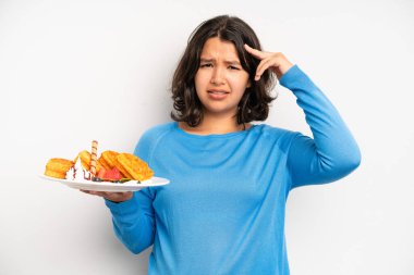 hispanic pretty girl smiling happily, waving hand, welcoming and greeting you. waffles breakfast concept