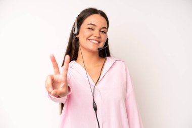 hispanic pretty woma smiling confidently pointing to own broad smile. telemarketer concept