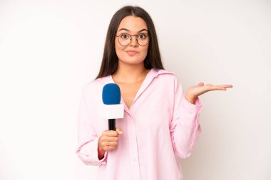 hispanic pretty woma smiling and looking friendly, showing number five. journalist with a microphone