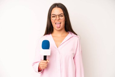 hispanic pretty woma looking shocked and surprised with mouth wide open, pointing to self. journalist with a microphone