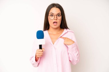 hispanic pretty woma feeling proud,smiling positively with thumbs up. journalist with a microphone