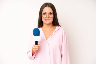hispanic pretty woma looking serious showing open palm making stop gesture. journalist with a microphone
