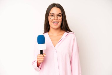 hispanic pretty woma feeling happy and pointing to self with an excited. journalist with a microphone