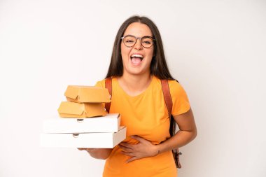 hispanic pretty woma smiling cheerfully, feeling happy and pointing to the side. delivery take away concept