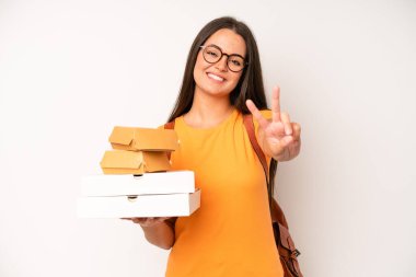 hispanic pretty woma smiling confidently pointing to own broad smile. delivery take away concept