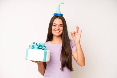 hispanic pretty woma making capice or money gesture, telling you to pay. birthday cake and celebration concept