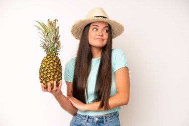 hispanic pretty woma looking desperate, frustrated and stressed. pineapple and summer concept