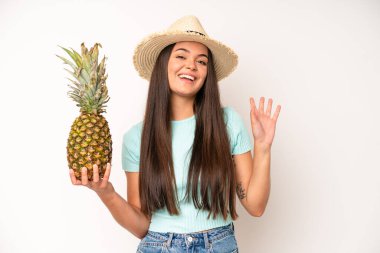 hispanic pretty woma looking happy and pleasantly surprised. pineapple and summer concept